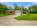 Ranch style house with attached two-car garage and wooden deck with chairs at 8000 Mcwhorter Rd, Martinsville, IN 46151