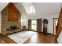 Cozy living room featuring a stone fireplace, hardwood floors, and a large window at 8465 Hilltop Ln, Martinsville, IN 46151