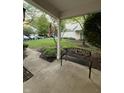 Inviting front yard with green lawn, mature trees, and a cozy bench on the porch at 9535 Longwell Dr, Indianapolis, IN 46240