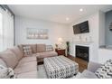 Relaxing living room with a fireplace, a plush sofa, and a patterned ottoman, perfect for gatherings at 9689 Wild Iris Dr, Noblesville, IN 46060