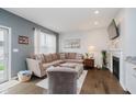 Comfortable living room featuring a fireplace, large sectional sofa, and natural light from the window at 9689 Wild Iris Dr, Noblesville, IN 46060