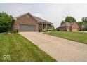 Spacious driveway leading to a well-maintained brick home with lush green lawn at 120 Wagon Trail, Mooresville, IN 46158