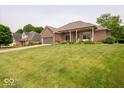 Beautiful brick home with large front yard, covered porch, and well-maintained landscaping at 120 Wagon Trail, Mooresville, IN 46158