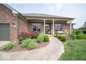 Inviting front porch with rocking chairs, landscaping, and brick exterior at 120 Wagon Trail, Mooresville, IN 46158