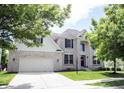 Beautiful two-story home with a brick exterior, well-maintained lawn, and mature trees, creating a welcoming and picturesque setting at 12093 Ashland Dr, Fishers, IN 46037