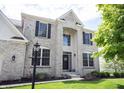 Inviting front entrance with a brick facade, well-lit doorway, and manicured landscaping, creating an inviting and elegant approach at 12093 Ashland Dr, Fishers, IN 46037