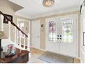Bright foyer with a staircase, decorative lighting, and elegant double doors leading to the outside at 1219 Driftwood Dr, Carmel, IN 46033