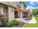 Beautiful front porch with a vibrant American flag, landscaped garden, and charming seating area at 1219 Driftwood Dr, Carmel, IN 46033
