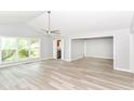 Open-concept living room featuring hardwood floors, a ceiling fan, and ample natural light at 12289 Charing Cross Rd, Carmel, IN 46033