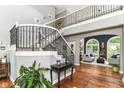 Elegant foyer with hardwood floors, wrought iron staircase, and a view into the bright and airy living room at 13017 Water Ridge Dr, McCordsville, IN 46055