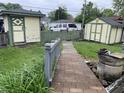 Spacious backyard featuring mature landscaping with a weathered fence and storage sheds at 1546 Wade St, Indianapolis, IN 46203