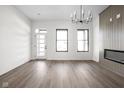 Open living room features an electric fireplace, modern light fixture, and hardwood flooring at 17339 Newton Main St, Westfield, IN 46074