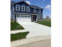 Charming two-story home with navy siding, white trim, a red door, and a spacious two-car garage at 2057 Eldin Ct, Whitestown, IN 46075