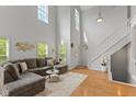 Bright living room with vaulted ceiling, hardwood floors, and comfortable sectional seating at 2075 Rhettsbury St, Carmel, IN 46032