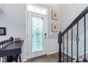 Welcoming foyer with decorative glass door and staircase with black iron railing at 2436 Gwinnett St, Carmel, IN 46032