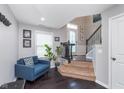 Cozy living space featuring a comfortable blue sofa and staircase at 2436 Gwinnett St, Carmel, IN 46032