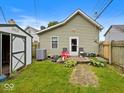 Backyard features a storage shed, partial fence and small patio with chairs, ideal for outdoor enjoyment at 334 E Pennsylvania St, Shelbyville, IN 46176