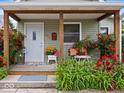 Charming front porch with colorful flowers and seating, framed by vibrant red roses and greenery at 334 E Pennsylvania St, Shelbyville, IN 46176