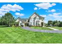 Elegant two-story residence with a circular driveway, verdant lawn, and convenient porte-cochère at 3398 Nottinghill Blvd, Plainfield, IN 46168