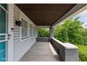 View of a covered front porch with painted brick pillars, and view to a grassy lawn at 3916 E 10Th St, Indianapolis, IN 46201