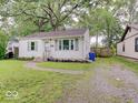 Quaint one-story home with a gravel driveway and mature trees providing ample shade at 4415 N Longworth Ave, Indianapolis, IN 46226