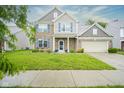 Inviting two-story home featuring brick facade, attached two-car garage, and a well-maintained front yard at 5374 John Quincy Adams Ct, Plainfield, IN 46168
