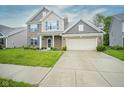 Charming two-story brick home featuring blue shutters, a two-car garage, and a well-maintained lawn at 5374 John Quincy Adams Ct, Plainfield, IN 46168
