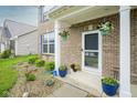 Charming brick home entrance with hanging flower baskets at 5374 John Quincy Adams Ct, Plainfield, IN 46168