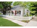 Charming home featuring a covered porch with swing, white picket fence, and American flag at 60 E Poplar St, Zionsville, IN 46077
