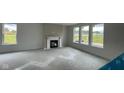 Spacious living room with large windows overlooking a pond and fireplace with white mantel at 6338 Rippling Rock Dr, Plainfield, IN 46168
