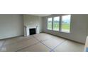Spacious living room featuring a fireplace and large windows with a view of the backyard at 6338 Rippling Rock Dr, Plainfield, IN 46168