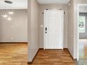 Inviting entryway with a white front door, modern lighting, and sleek laminate flooring throughout at 7061 Blankenship Ave, Indianapolis, IN 46217