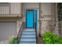 Close-up of a vibrant blue front door with decorative glass, accented by stone facade and manicured landscaping at 7831 Eagle Valley Pass, Indianapolis, IN 46214