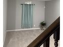 Light-filled carpeted room featuring a decorative curtain and a small potted plant at 8241 Morera Ct, Indianapolis, IN 46237