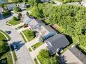 An aerial view showcases a quiet neighborhood with well-kept homes and verdant green spaces on a sunny day at 9229 Crossing Dr, Fishers, IN 46037