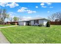 Attractive white brick home with neat landscaping, a spacious lawn, and an attached garage at 1111 Cambridge Dr, Greenwood, IN 46142