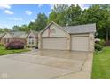 Charming brick home boasts a well-manicured lawn and attached three car garage at 1124 Enchanted View Dr, Mooresville, IN 46158
