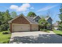 Beautiful brick and siding home featuring an attached two-car garage with a long driveway at 12335 Old Stone Dr, Indianapolis, IN 46236