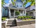 Charming exterior view of a two-story home with a welcoming front porch and landscaped garden at 1322 Marlowe Ave, Indianapolis, IN 46202