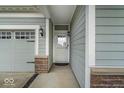 Close-up of the home's entry, highlighting the sidelight windows, attached two car garage, and craftsman details at 13495 Forest Glade Dr, Fishers, IN 46037