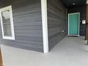Inviting front porch featuring a bright teal door, modern railings, and a smooth, updated concrete floor at 1518 S Talbott St, Indianapolis, IN 46225