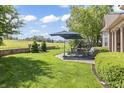 Lush backyard features a stone patio with ample seating and manicured landscaping at 16502 Grand Cypress Dr, Noblesville, IN 46060