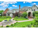 View of a well landscaped circular driveway with a water feature in the yard of the home at 20170 Starlight Ct, Noblesville, IN 46062