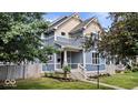Charming two-story home featuring blue siding and a well-maintained lawn and landscaped garden at 2448 Broadway St, Indianapolis, IN 46205