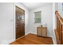 Bright foyer with hardwood floors, a stylish cabinet, and natural light streaming through the window at 2448 Broadway St, Indianapolis, IN 46205