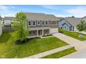 This aerial view showcases a well-maintained, two-story home with a two car garage and lush front lawn at 2626 Solidago Dr, Plainfield, IN 46168