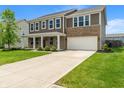 Two-story home with two-car garage, brick and siding exterior, manicured lawn and long driveway at 2626 Solidago Dr, Plainfield, IN 46168