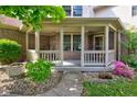 Inviting front porch with brick accents, flower arrangements, and a cozy seating area at 286 N Greenbriar Dr, Greenwood, IN 46142