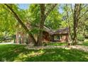 Charming home featuring a brick and wood facade, a red door, and mature trees in a landscaped front yard at 3479 Sugar Loaf Ct, Carmel, IN 46033