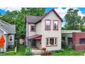 Charming two-story home with light siding, red trim, and lush landscaping in a residential neighborhood at 514 Dorman St, Indianapolis, IN 46202